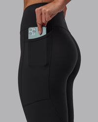 Woman wearing Rep Ultra High-Rise 7/8 Legging Pockets - Pirate Black-White | Model:Blaize | Size:S