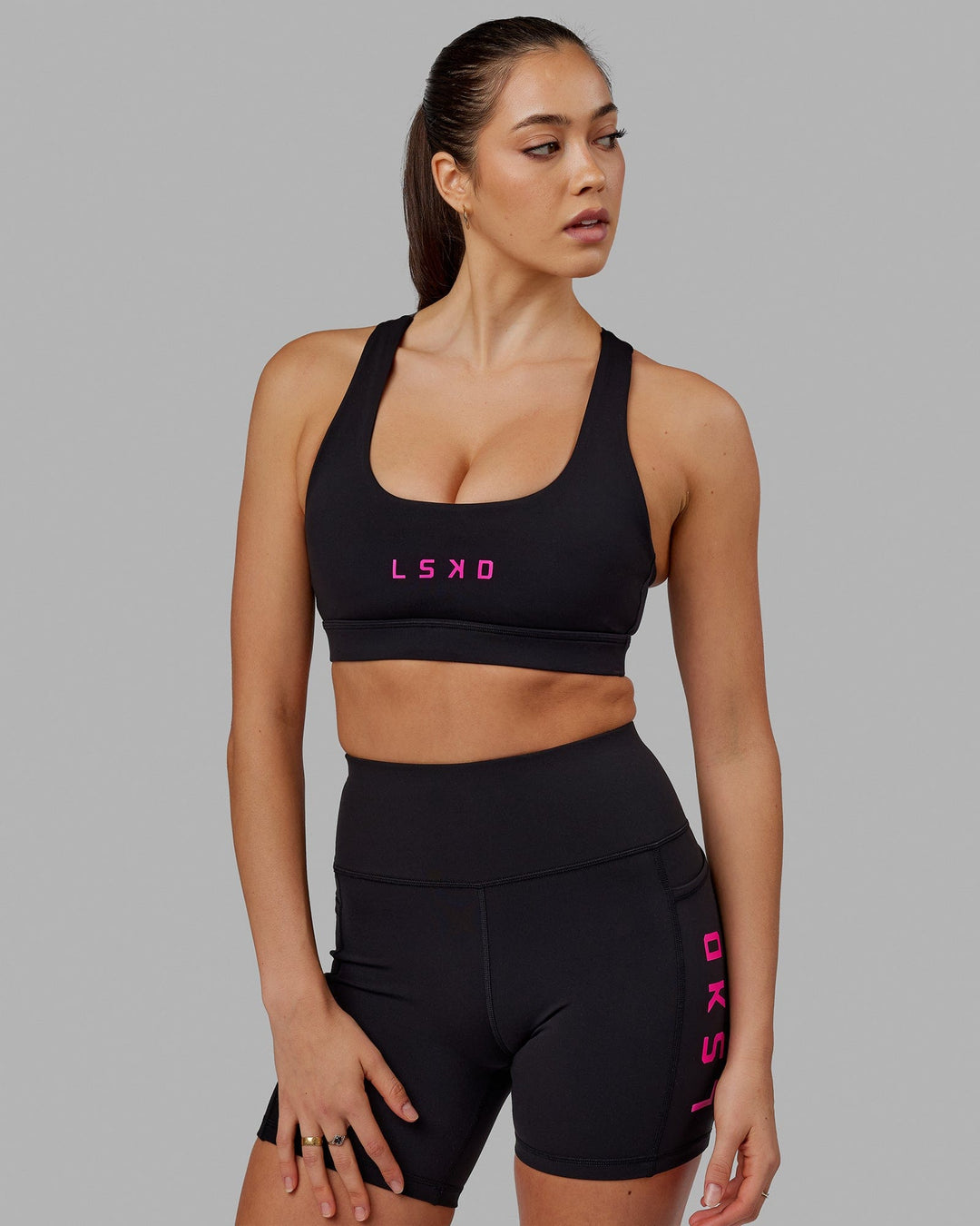 Woman wearing Rep Sports Bra Small Logo - Black-Neon Magenta