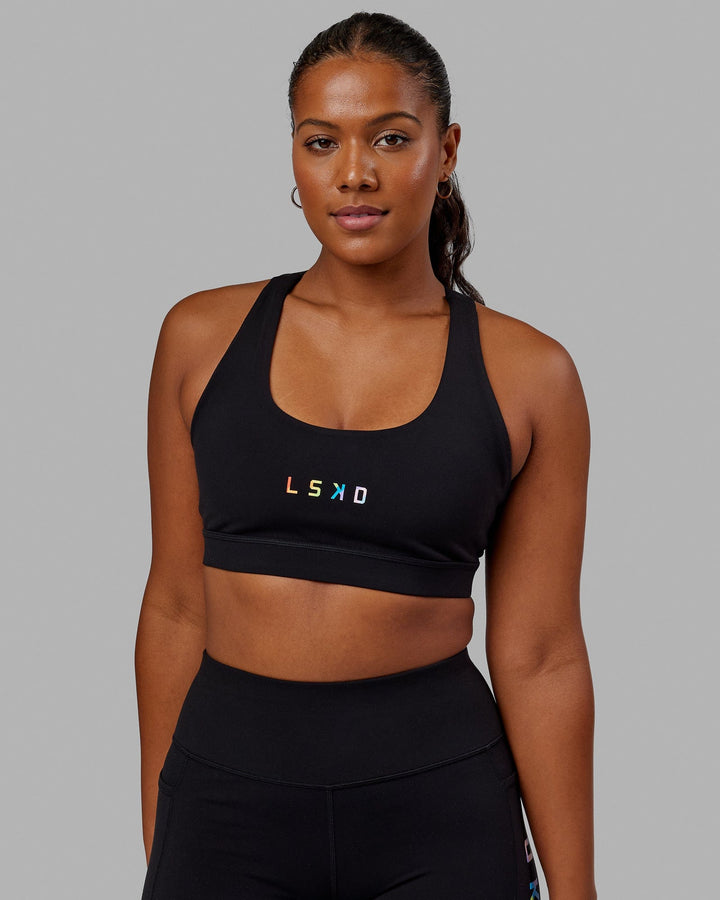 Woman wearing Rep Sports Bra Small Logo - Pride-Black