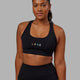 Woman wearing Rep Sports Bra Small Logo - Pride-Black