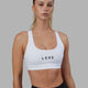 Woman wearing Rep Sports Bra Small Logo - White-Black
