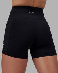 Women wearing O.G. Rep Ultra High-Rise 4" Short Pockets - Black-White | Model:Shae | Size:S