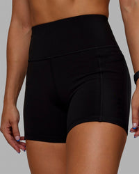Woman wearing O.G. Rep Ultra High-Rise 4" Short Pockets - Black-Black | Model:Abbey| Size:S