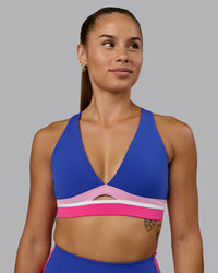 Woman wearing Revitalise Sports Bra - Power Cobalt-Fuchsia Pink