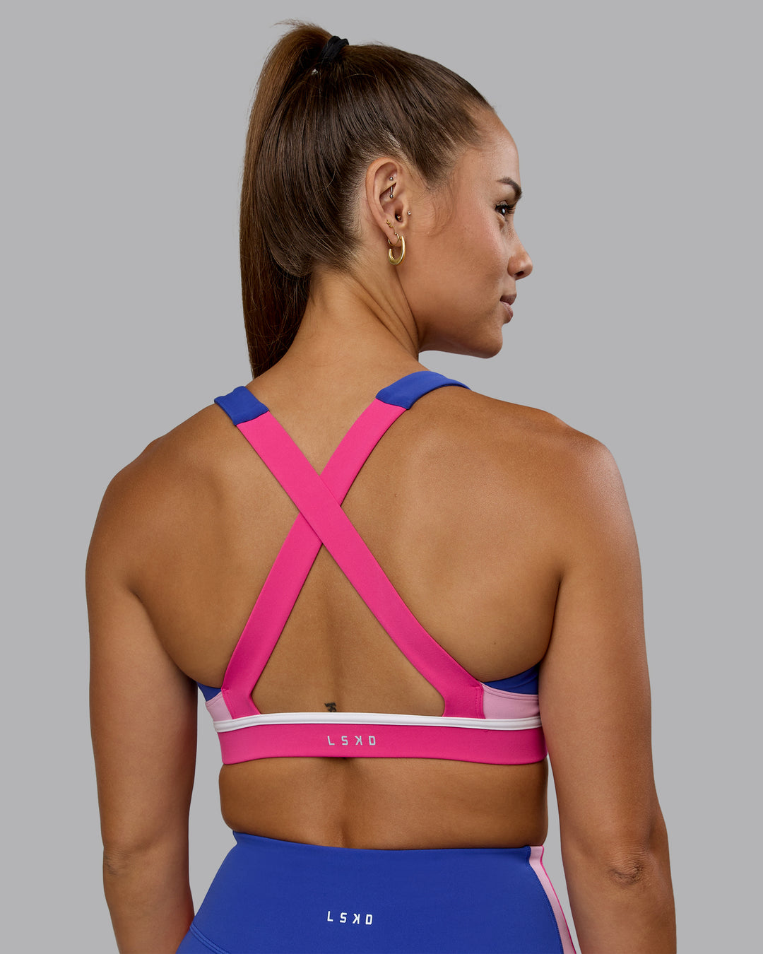 Woman wearing Revitalise Sports Bra - Power Cobalt-Fuchsia Pink