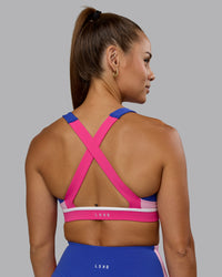 Woman wearing Revitalise Sports Bra - Power Cobalt-Fuchsia Pink