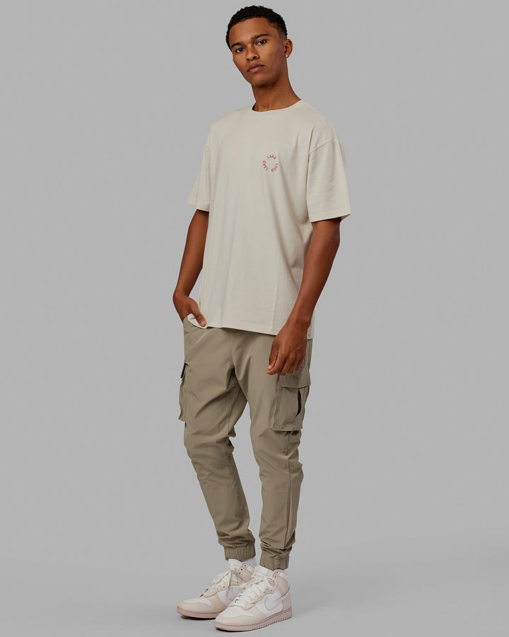 Man wearing Unisex Rotate Tee Oversize - Bone-Mineral Red