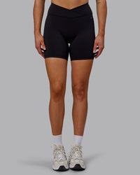 Woman wearing Sara Strike Ultra High-Rise Cross Over Waist 6" Short - Black