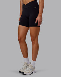 Woman wearing Sara Strike Ultra High-Rise Cross Over Waist 6" Short - Black