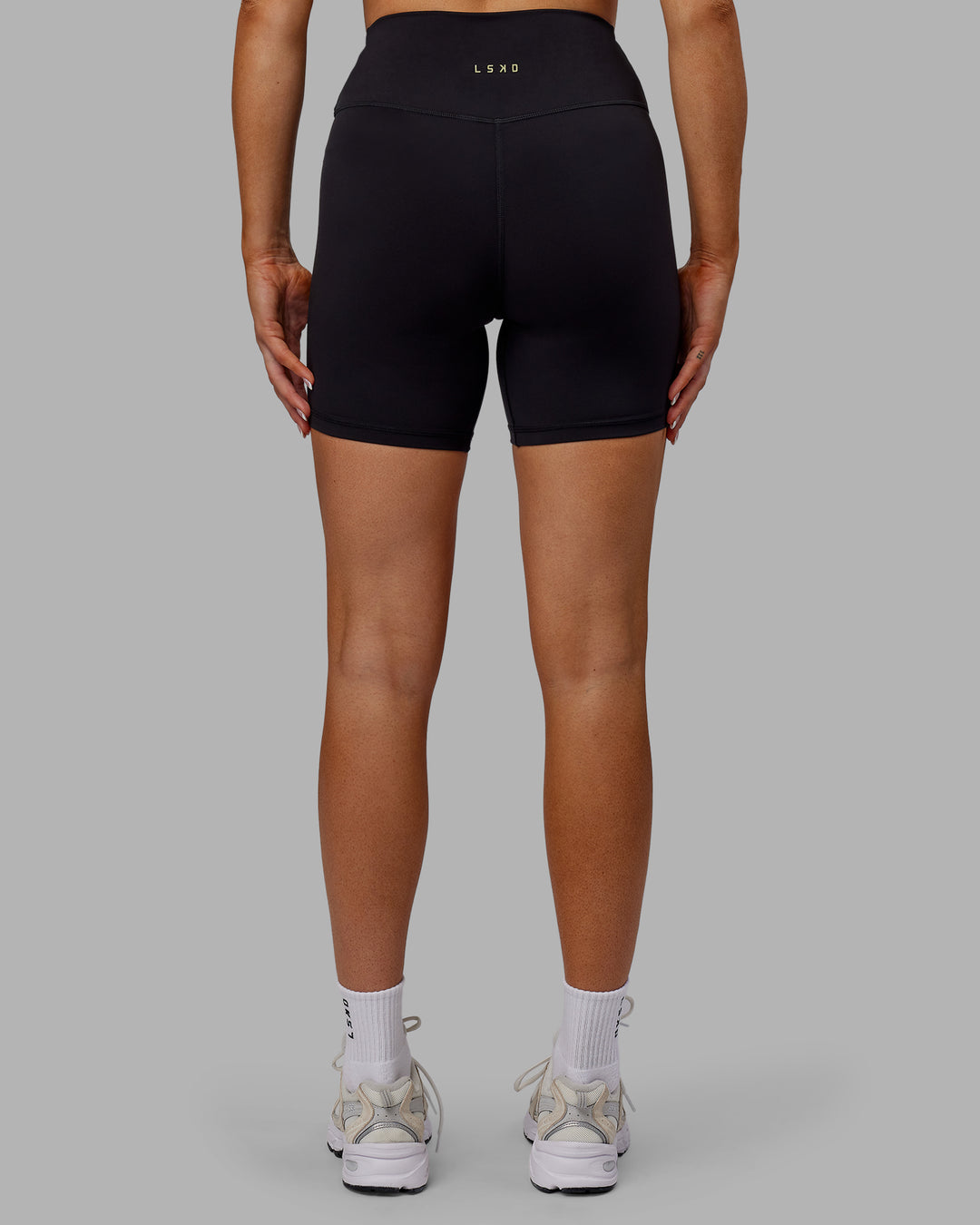 Woman wearing Sara Strike Ultra High-Rise Cross Over Waist 6" Short - Black