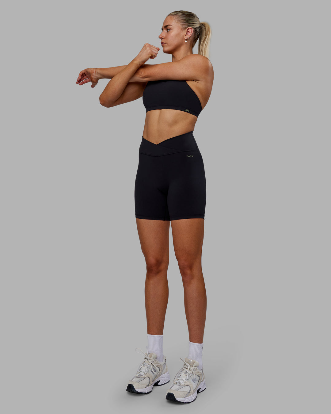 Woman wearing Sara Strike Ultra High-Rise Cross Over Waist 6" Short - Black