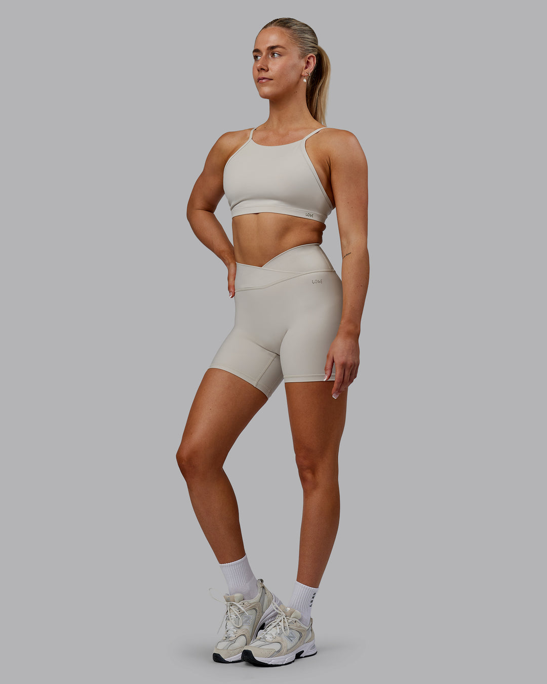 Woman wearing Sara Strike Ultra High-Rise Cross Over Waist 6&quot; Short - Shale Beige