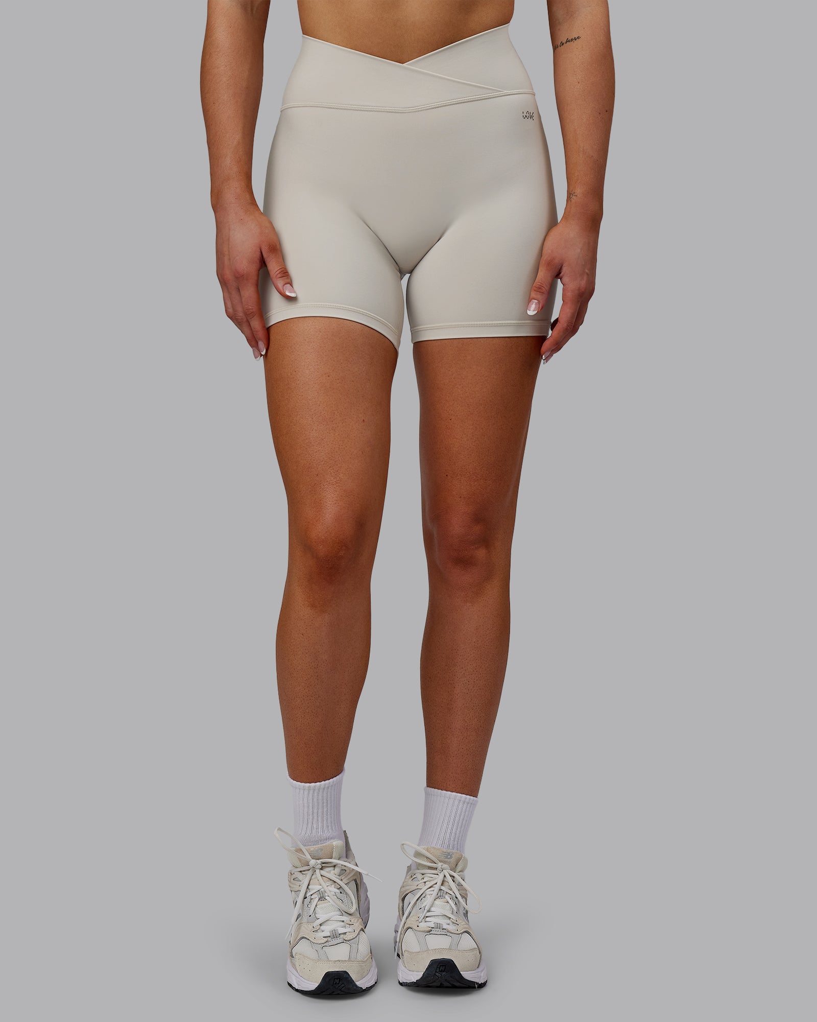 Woman wearing Sara Strike Ultra High-Rise Cross Over Waist 6" Short - Shale Beige