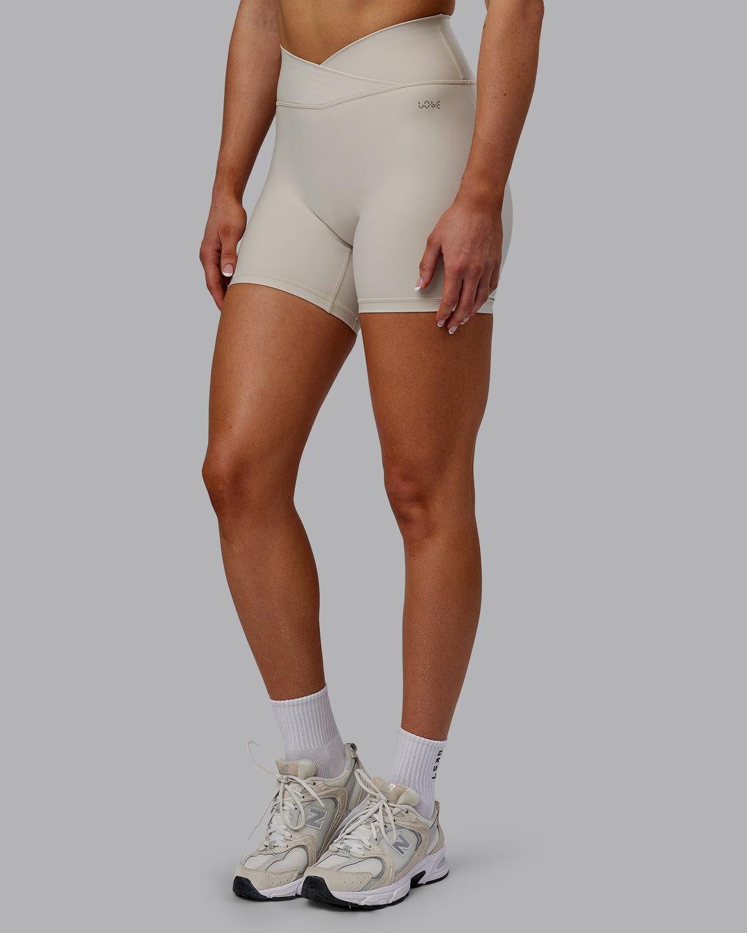Woman wearing Sara Strike Ultra High-Rise Cross Over Waist 6&quot; Short - Shale Beige
