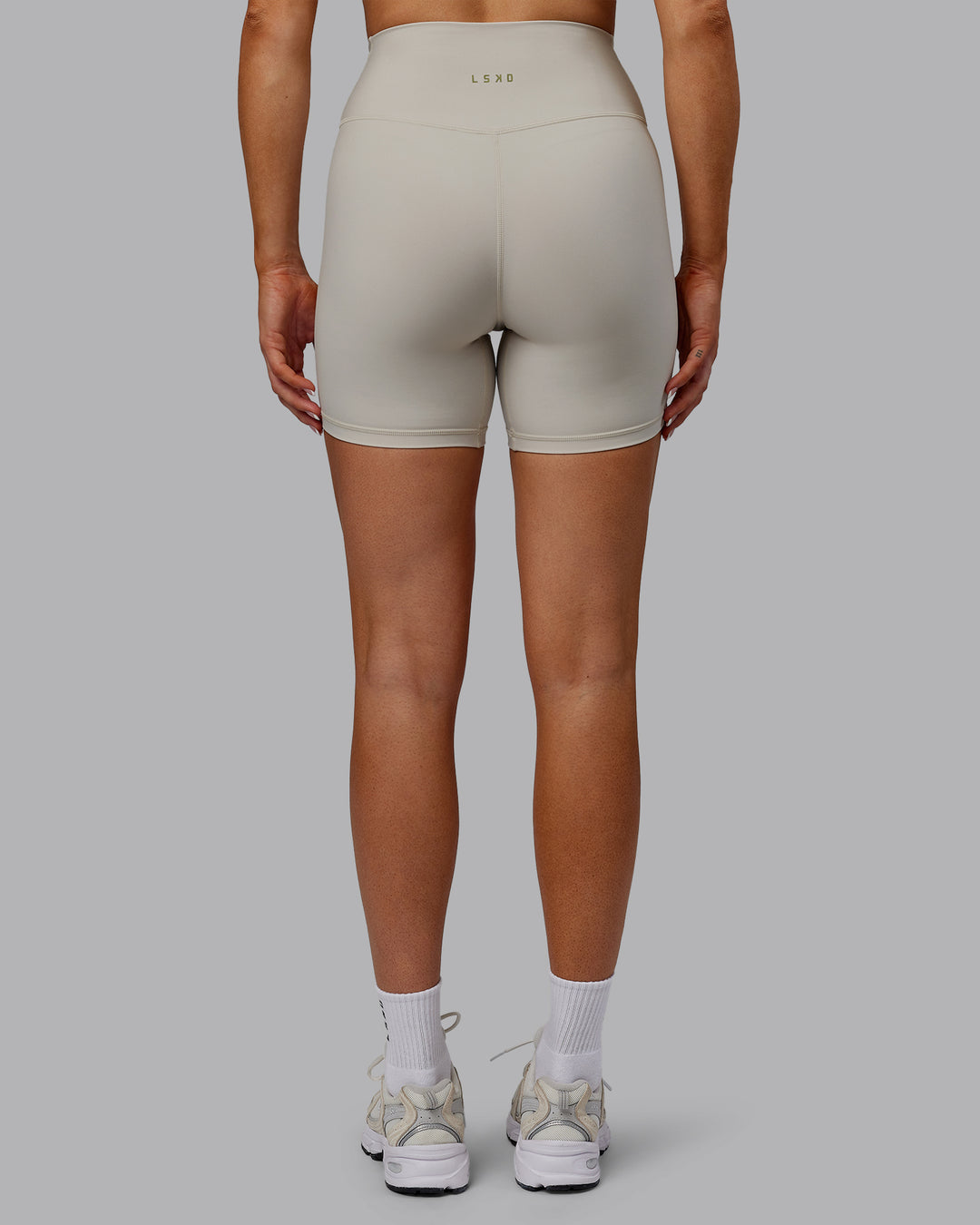 Woman wearing Sara Strike Ultra High-Rise Cross Over Waist 6&quot; Short - Shale Beige
