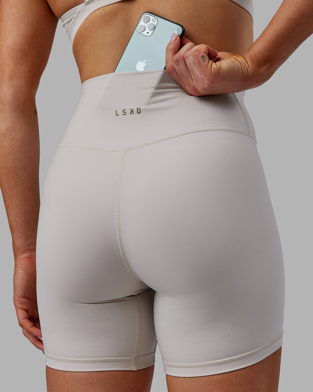Woman wearing Sara Strike Ultra High-Rise Cross Over Waist 6&quot; Short - Shale Beige