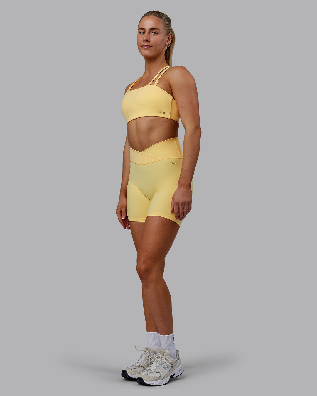 Woman wearing Sara Strike Ultra High-Rise Cross Over Waist 6&quot; Short - Sunflower