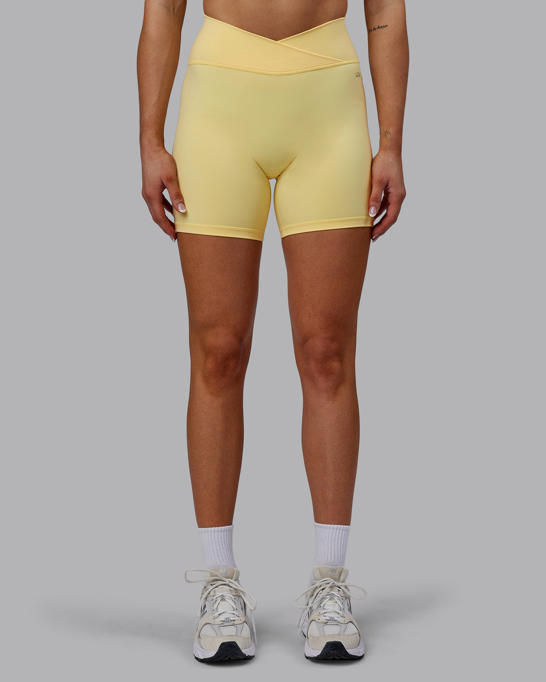 Woman wearing Sara Strike Ultra High-Rise Cross Over Waist 6&quot; Short - Sunflower