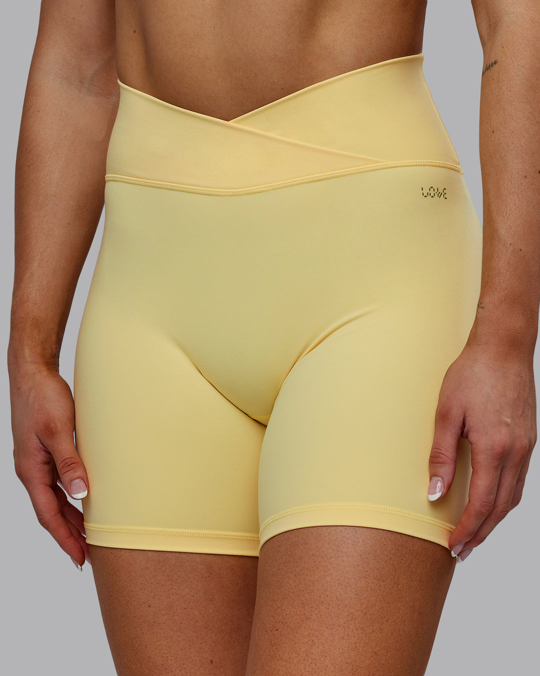 Woman wearing Sara Strike Ultra High-Rise Cross Over Waist 6&quot; Short - Sunflower