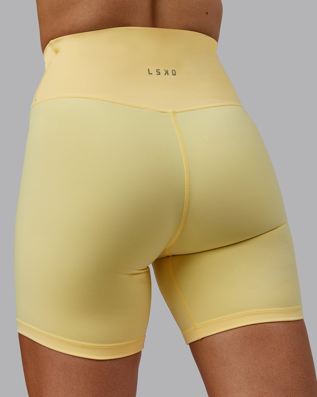 Woman wearing Sara Strike Ultra High-Rise Cross Over Waist 6&quot; Short - Sunflower