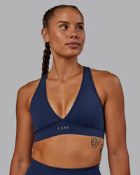 Woman wearing Stamina Sports Bra - Future Navy | Set:true | Angle:front | Model:Vanessa | Size:S