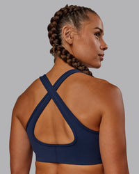 Woman wearing Stamina Sports Bra - Future Navy | Set:true | Angle:back | Model:Vanessa | Size:S