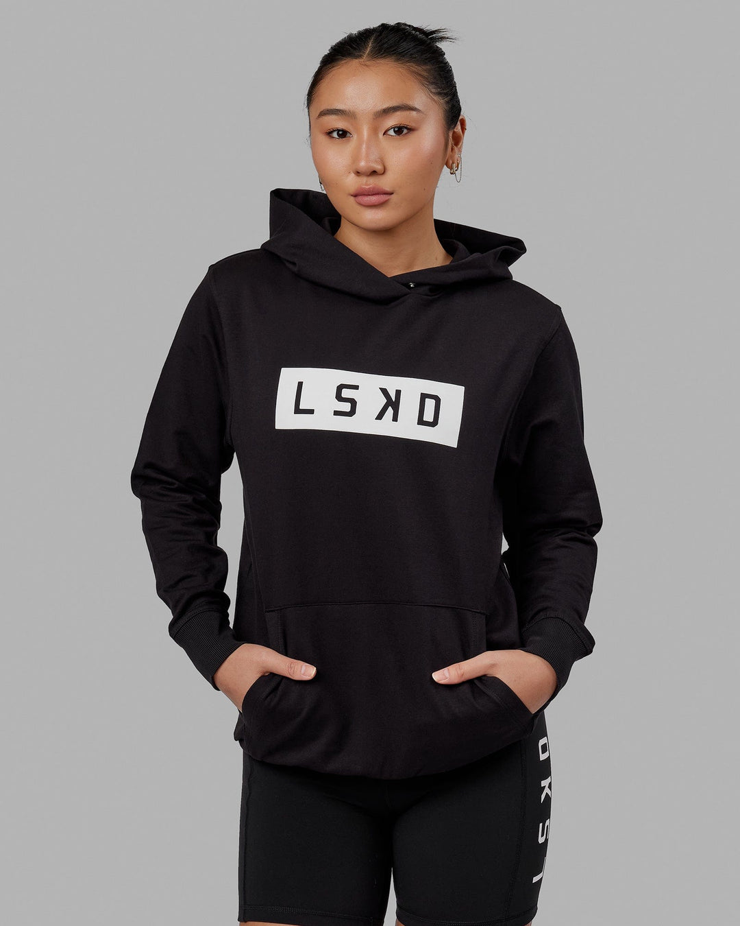 Woman wearing Unisex Strength FLXFLeece Hoodie - Black-White