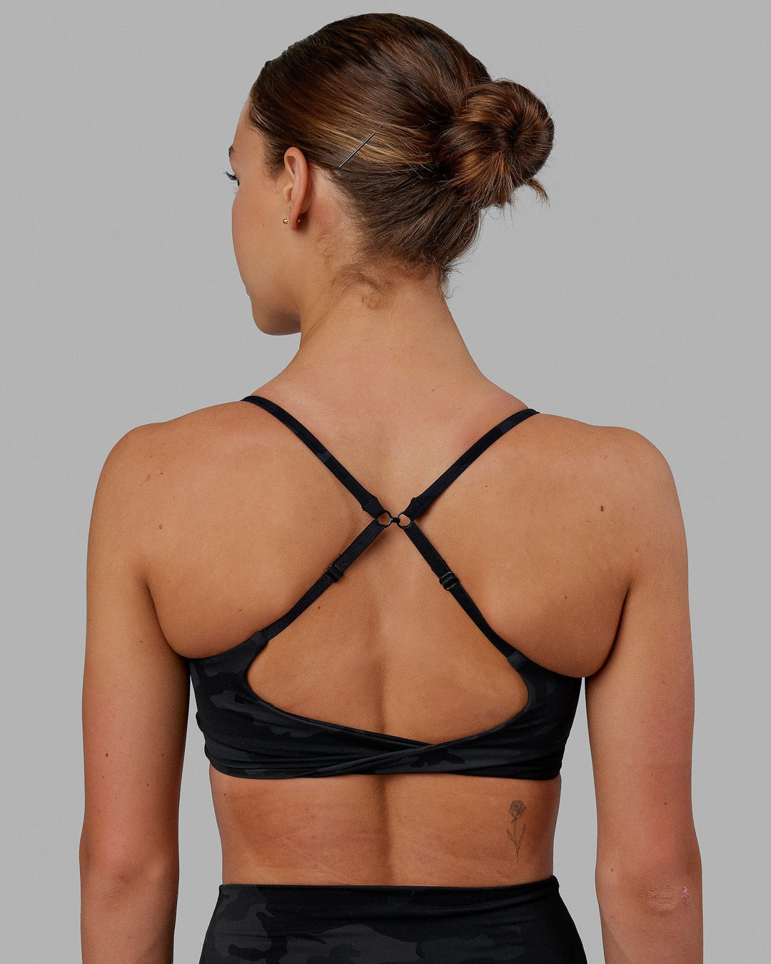 Woman wearing Twist Sports Bra - Black Camo