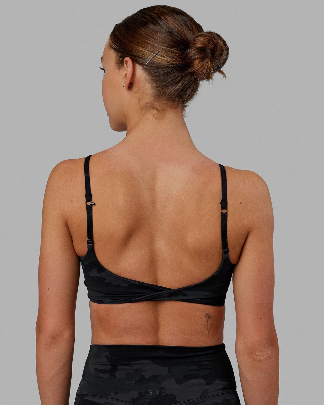 Woman wearing Twist Sports Bra - Black Camo