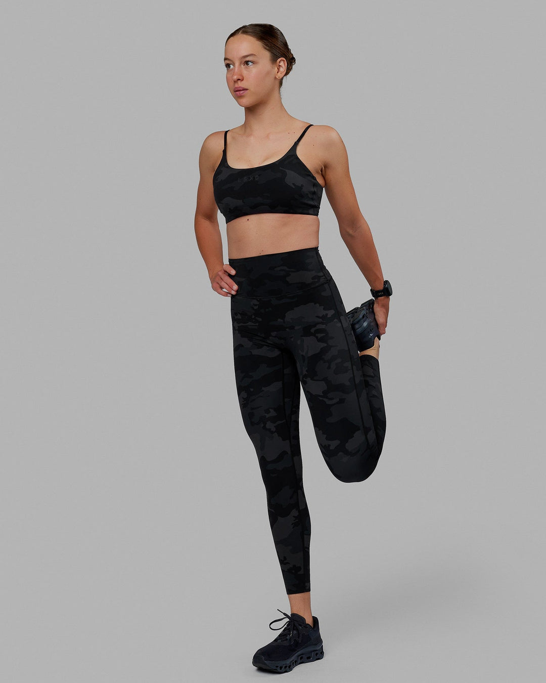 Woman wearing Twist Sports Bra - Black Camo