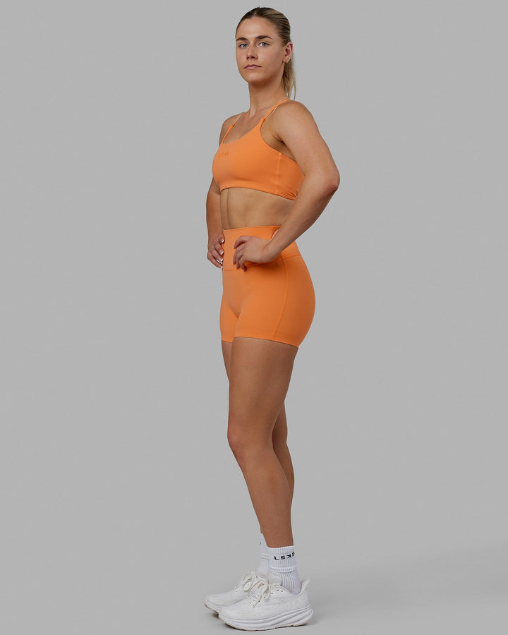 Woman wearing Twist Sports Bra - Tangerine