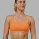 Woman wearing Twist Sports Bra - Tangerine