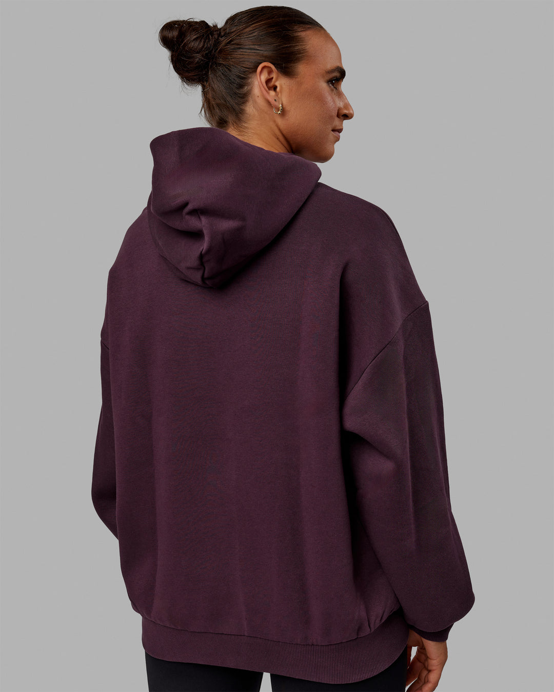 Woman wearing Unisex 1% Better Hoodie Oversize - Midnight Plum