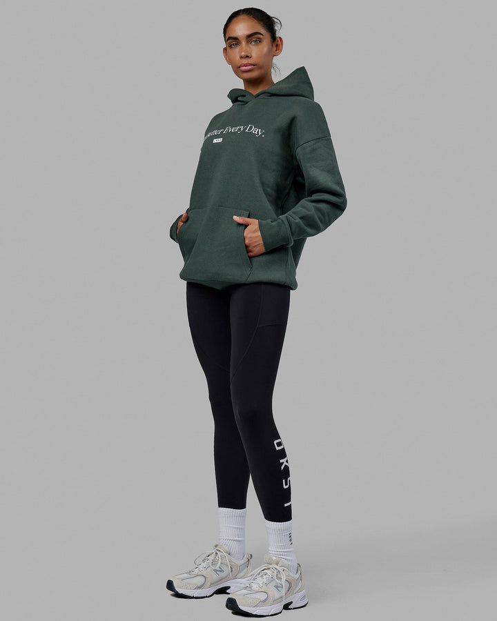 Woman wearing Unisex 1% Better Hoodie Oversize - Vital Green