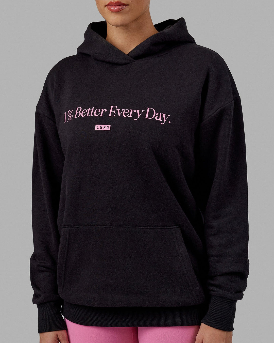 Woman wearing Unisex 1% Better Hoodie Oversize - Black-Pink Rose