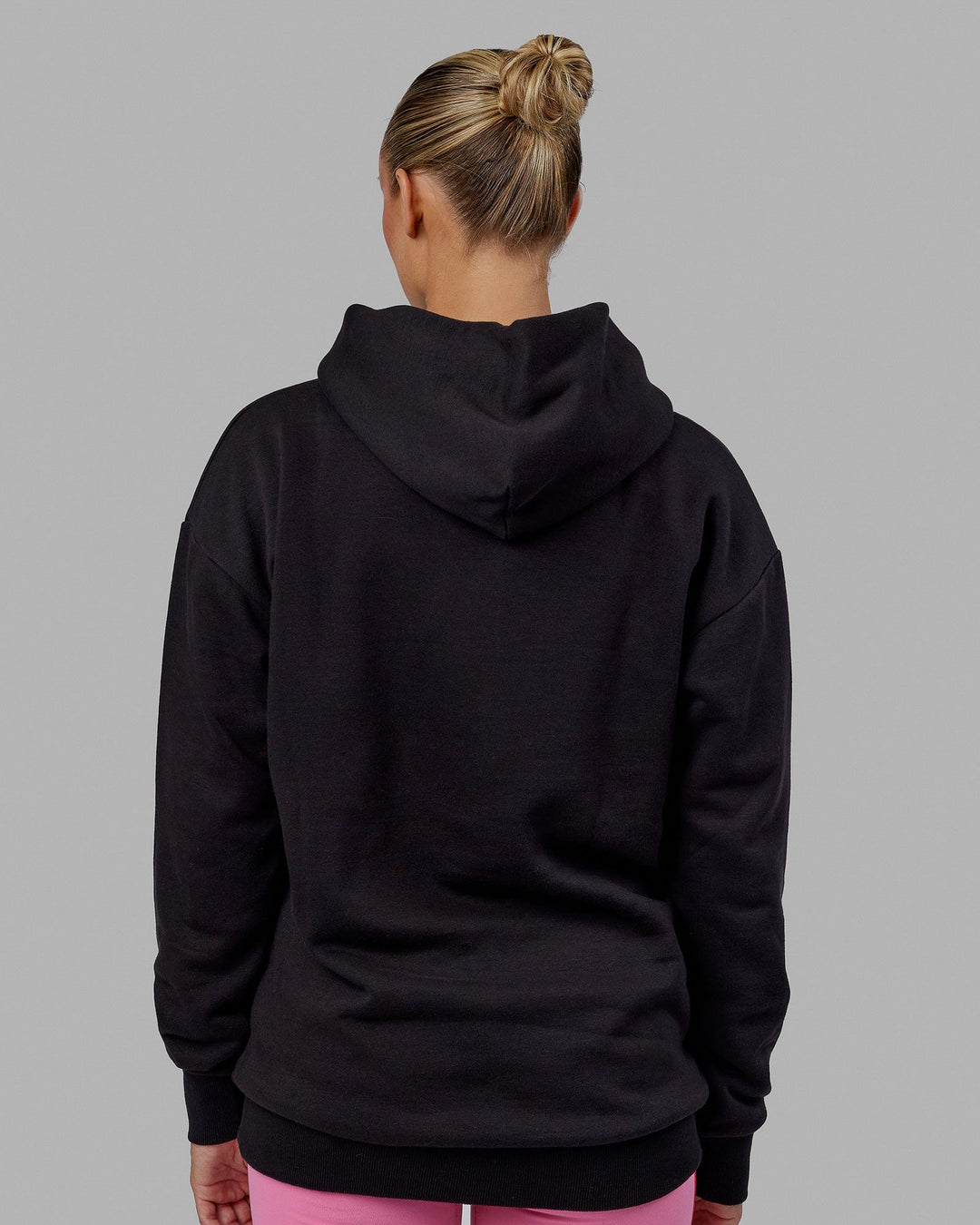 Woman wearing Unisex 1% Better Hoodie Oversize - Black-Pink Rose