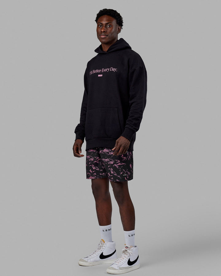 Man wearing Unisex 1% Better Hoodie Oversize - Black-Pink Rose