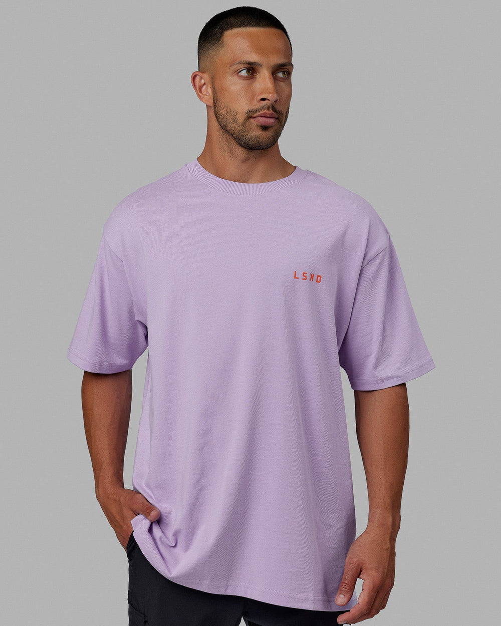 Man wearing Unisex Endeavour Heavyweight Tee Oversize - Pale Lilac-Impact Orange