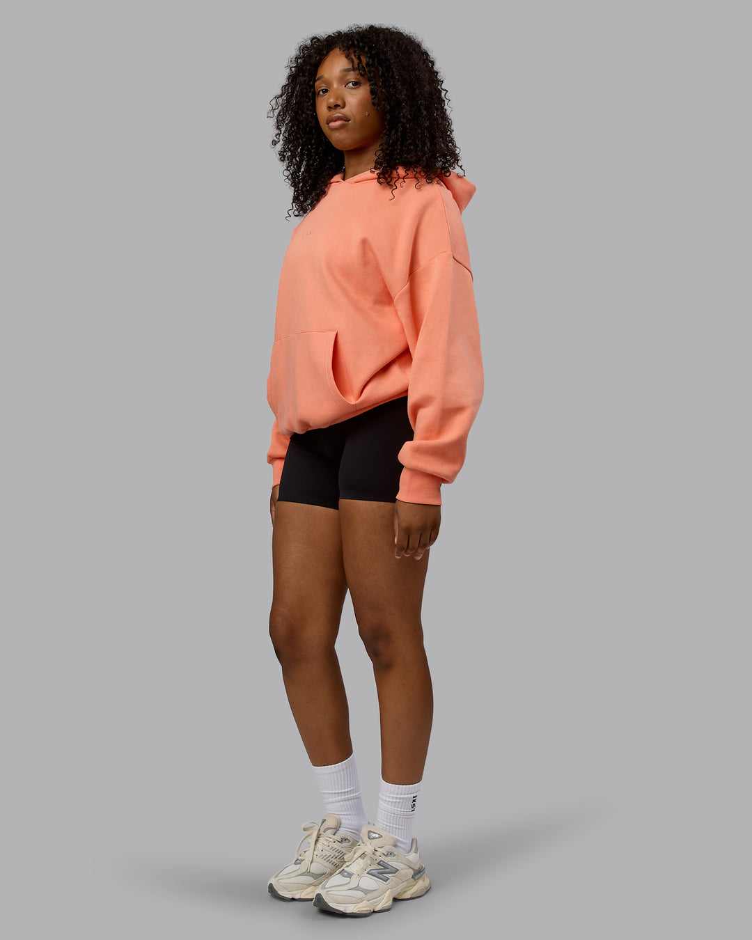 Woman wearing Unisex MVP Hoodie Oversize - Mellow Peach