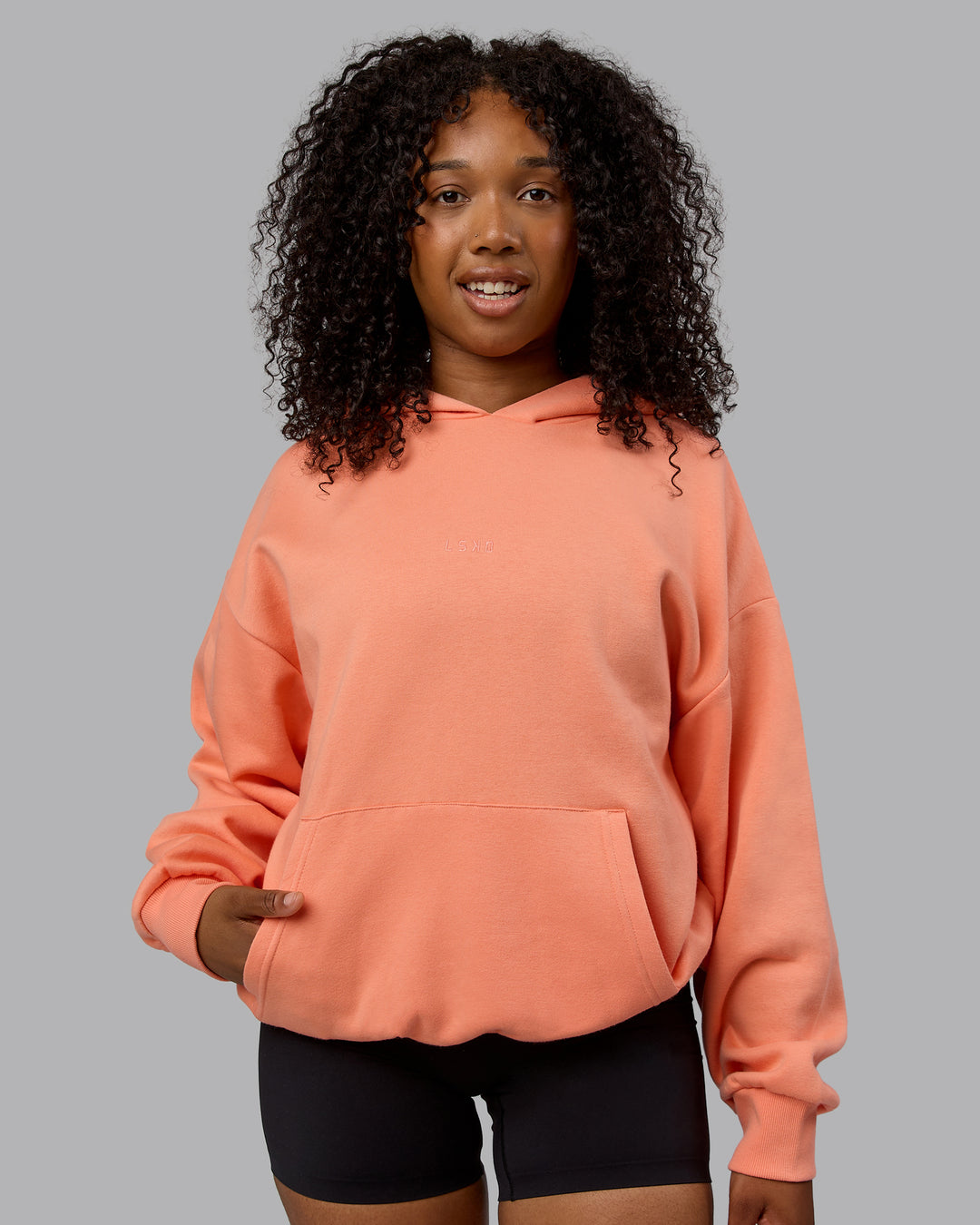 Woman wearing Unisex MVP Hoodie Oversize - Mellow Peach