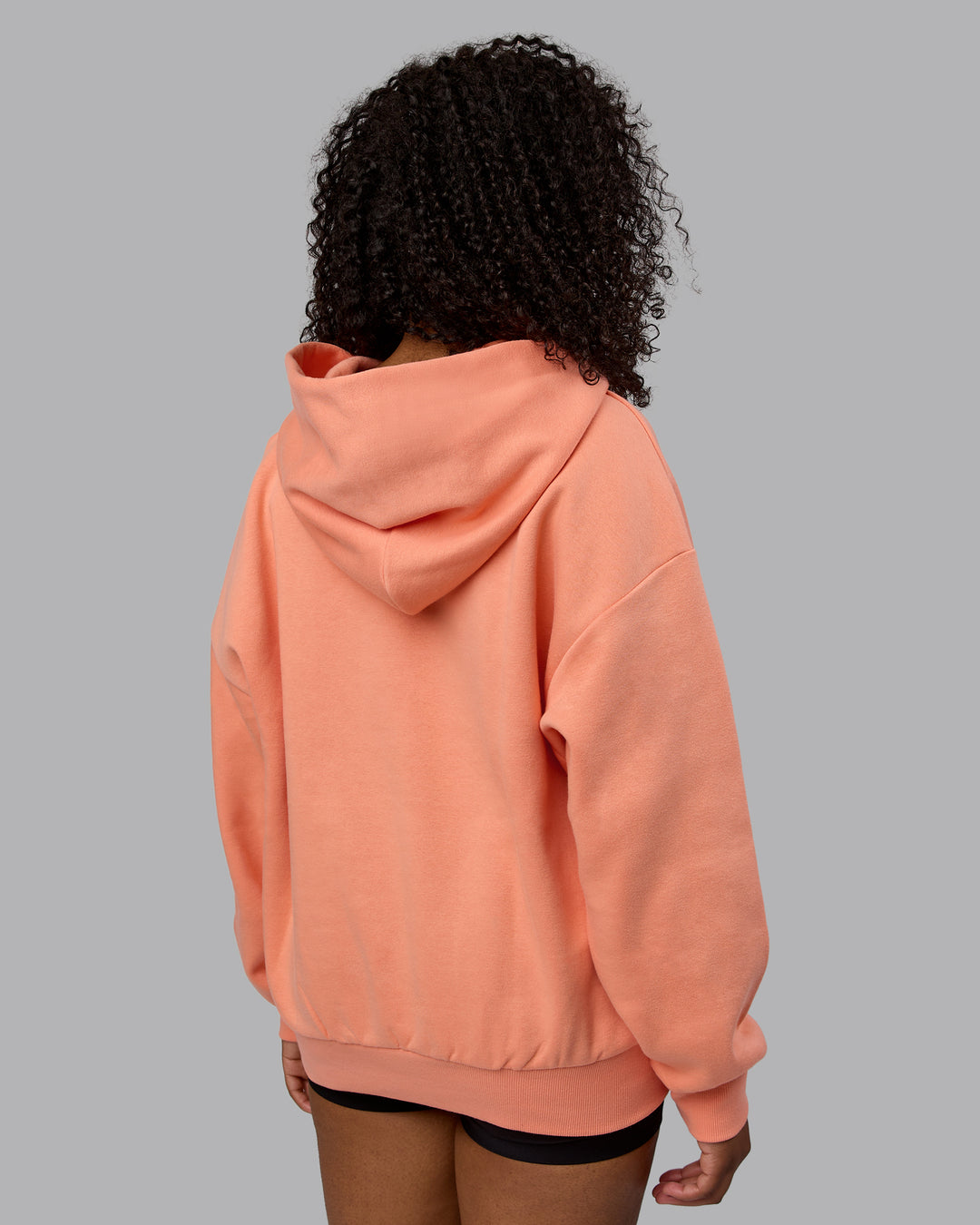 Woman wearing Unisex MVP Hoodie Oversize - Mellow Peach