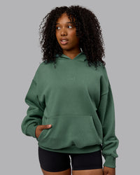 WOman wearing Unisex MVP Hoodie Oversize - Sage Brush
