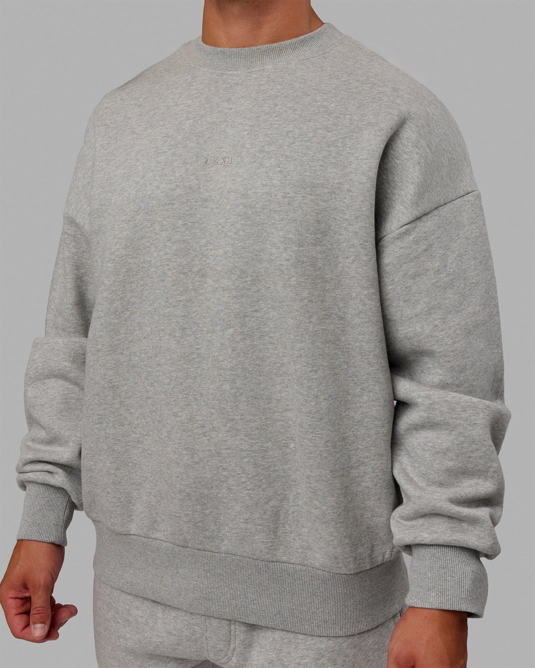 Man wearing Unisex MVP Sweater Oversize - Lt Grey Marl