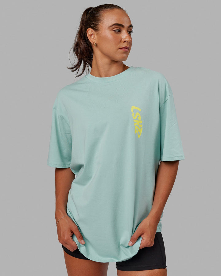 Woman wearing Unisex Miami24 FLXCotton Tee Oversize - Pastel Turquoise-Yellow