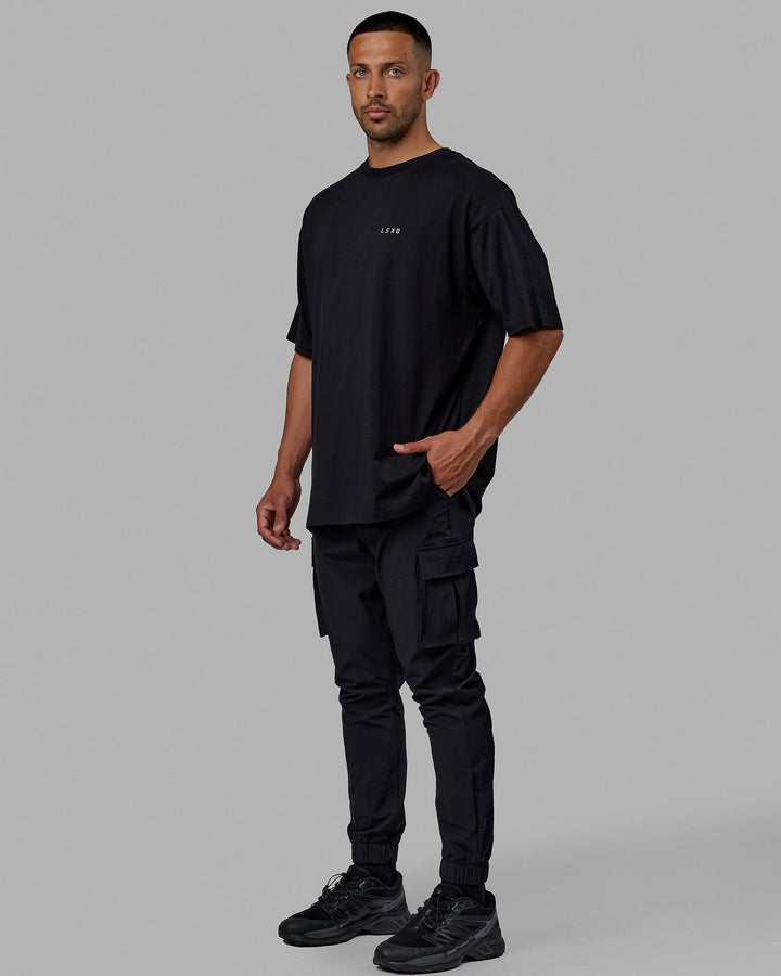Man wearing Unisex PimaFLX Tee Oversize - Black