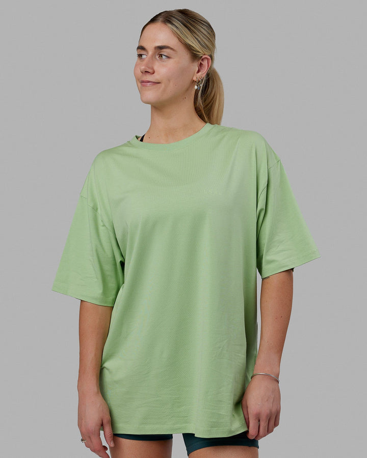 Woman wearing Unisex PimaFLX Tee Oversize - Green Fig