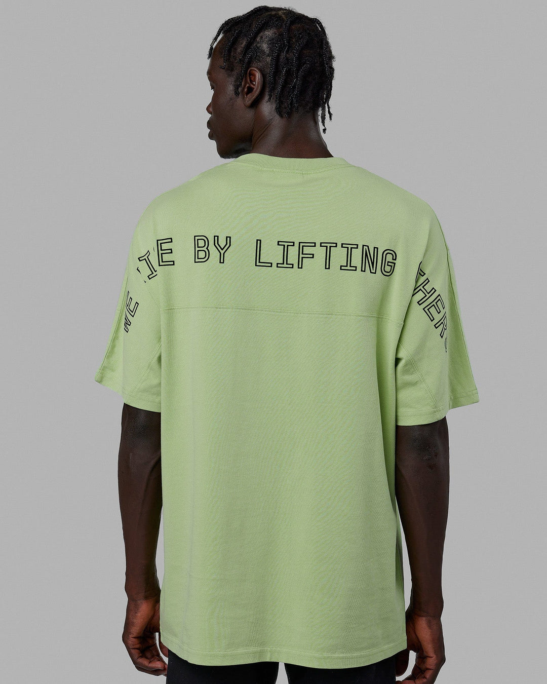 Man wearing Unisex Rise & Lift Heavyweight Tee Oversize - Washed Green Fig