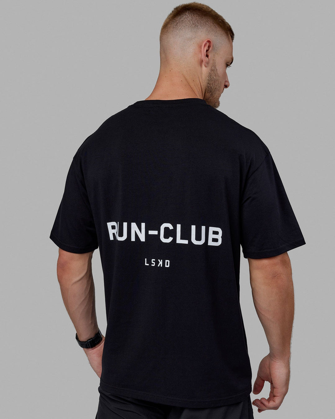 Man wearing Unisex RUN–CLUB FLXCotton Tee Oversize - Black-White