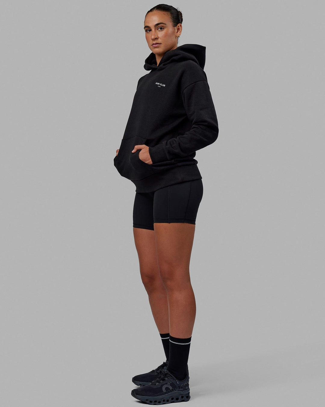 Woman wearing Unisex RUN-CLUB Hoodie Oversize - Black