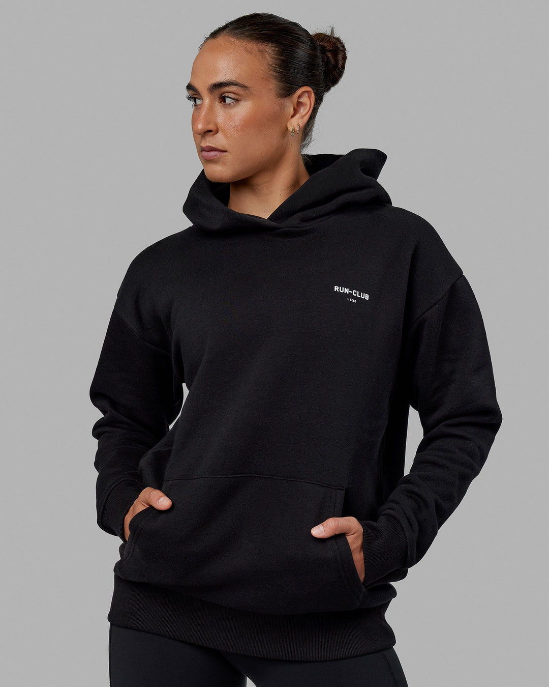 Woman wearing Unisex RUN-CLUB Hoodie Oversize - Black